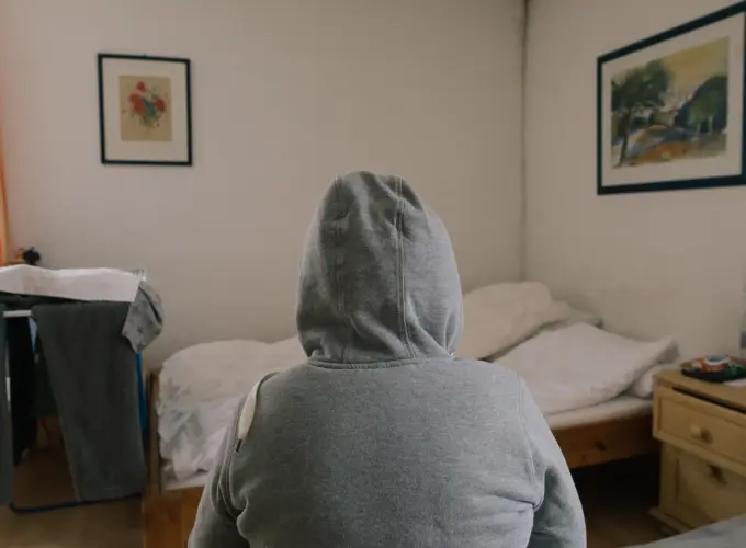 Anastasia Petrenko (Name geändert) sitzt auf einem der drei Betten in der Unterkunft.